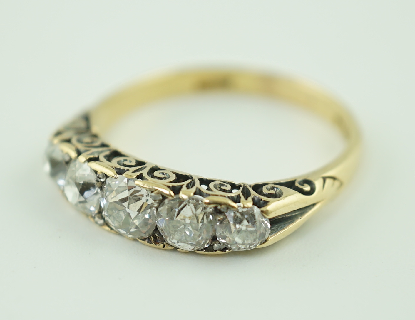 An early 20th century 18ct gold and graduated five stone old cut diamond set half hoop ring